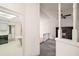 View from a hallway into the kitchen and Gathering room featuring white interior walls and neutral flooring at 24 Brigadoon Cir, Leesburg, FL 34788