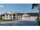 An elegant home features a spacious driveway, large windows, and a three-car garage with unique cross beam garage doors at 2421 Shady Ln, Groveland, FL 34736