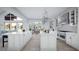 Spacious kitchen featuring an island, stainless steel appliances, white cabinetry, and a view of the living room at 2421 Shady Ln, Groveland, FL 34736