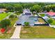 Aerial view of blue house with long driveway, inground pool in screened enclosure, and a fire hydrant on the lawn at 2705 Bayview Dr, Eustis, FL 32726