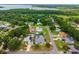Aerial view of a residential neighborhood with tree-lined streets and a serene lake backdrop at 2705 Bayview Dr, Eustis, FL 32726