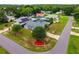 Aerial view of the blue house with lush green grass, mature trees, landscaped areas, and a fire hydrant on the lawn at 2705 Bayview Dr, Eustis, FL 32726