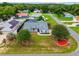 Aerial view of blue single-story home with lush green lawn, mature trees, and landscaped areas, and a fire hydrant at 2705 Bayview Dr, Eustis, FL 32726