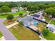 Aerial view of blue house with pool in screened enclosure, paver patio, lush lawns and a fire hydrant in the yard at 2705 Bayview Dr, Eustis, FL 32726
