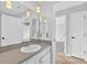 Bathroom featuring large mirrors above sink area, neutral wall paint, and an open door with access to other rooms at 2705 Bayview Dr, Eustis, FL 32726