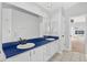 Bright bathroom with a double sink vanity featuring white cabinets and a dark countertop, plus an entrance to the pool area at 2705 Bayview Dr, Eustis, FL 32726