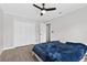 Comfortable bedroom with wood-look floors, a ceiling fan, and a double-door closet for ample storage at 2705 Bayview Dr, Eustis, FL 32726