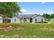 Charming single-story home features arched windows, fresh landscaping, a shade tree, and a well-maintained lawn at 2705 Bayview Dr, Eustis, FL 32726