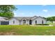 Charming single-story home featuring arched windows, fresh landscaping, and a well-manicured lawn at 2705 Bayview Dr, Eustis, FL 32726