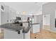 Well-lit kitchen boasts stainless steel appliances, gray cabinets, and a convenient island, ideal for meal preparation and storage at 2705 Bayview Dr, Eustis, FL 32726