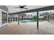 Covered patio area with a ceiling fan overlooking a screened-in pool surrounded by a concrete deck at 2705 Bayview Dr, Eustis, FL 32726
