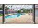 View of the screened-in pool showcasing the clear water, surrounding greenery, and tiled accents at 2705 Bayview Dr, Eustis, FL 32726