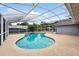 Inviting screened-in pool featuring clear blue water, spacious deck, and lush landscaping at 2705 Bayview Dr, Eustis, FL 32726