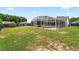 Wide shot of a screened-in pool with a well-maintained lawn and partial view of the house at 2705 Bayview Dr, Eustis, FL 32726