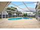Screened-in pool area with clear blue water and surrounding concrete deck, perfect for relaxation at 2705 Bayview Dr, Eustis, FL 32726