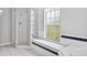 Well-lit bathroom featuring a glass-enclosed shower, bright window and tiled bench, offering a clean and open design at 2705 Bayview Dr, Eustis, FL 32726