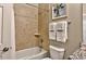 A bathroom with a shower-tub combo, light-colored tile surround, and a toilet with towels nearby at 27121 White Plains Way, Leesburg, FL 34748
