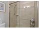 Walk-in shower featuring a glass door, light-colored tile surround, and a shower head at 27121 White Plains Way, Leesburg, FL 34748