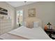 Well-lit bedroom features a queen-size bed, artwork, and natural light from a window with shutters at 27121 White Plains Way, Leesburg, FL 34748