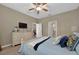 Comfortable bedroom boasts hardwood floors, a ceiling fan, and a neutral color scheme at 27121 White Plains Way, Leesburg, FL 34748