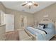Comfortable bedroom features a ceiling fan, neutral walls, and a queen-size bed with decorative pillows at 27121 White Plains Way, Leesburg, FL 34748