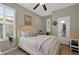 Bright bedroom features plantation shutters, wood flooring, and a queen-size bed at 27121 White Plains Way, Leesburg, FL 34748