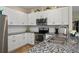 Stylish kitchen featuring stainless steel appliances, granite countertops, and white cabinets for a sleek finish at 27121 White Plains Way, Leesburg, FL 34748