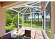 Comfortable seating area in the screened lanai offering scenic backyard views at 27121 White Plains Way, Leesburg, FL 34748