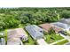 An aerial view shows the house with a gray roof and lush, green landscaping at 27302 Stoney Brook Dr, Leesburg, FL 34748