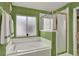 Bathroom with soaking tub, shower, and green walls at 27302 Stoney Brook Dr, Leesburg, FL 34748