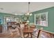 Open-concept dining and living rooms with hardwood floors and bright natural light from sliding glass door at 27302 Stoney Brook Dr, Leesburg, FL 34748