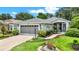 Charming home with lush landscaping, a two-car garage, and inviting walkway at 27302 Stoney Brook Dr, Leesburg, FL 34748
