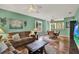 Cozy living room with comfortable seating, a ceiling fan, and wood-look floors at 27302 Stoney Brook Dr, Leesburg, FL 34748