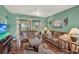 Well-lit living room featuring plush sofas, hardwood floors, and a large television at 27302 Stoney Brook Dr, Leesburg, FL 34748