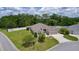 An aerial view displays a landscaped yard with a well maintained beige home with a cul-de-sac at 2954 Heiny Pl, The Villages, FL 32163