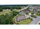 Aerial view of this home in a verdant neighborhood with a white fence and landscaping detail at 2954 Heiny Pl, The Villages, FL 32163