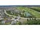 Expansive aerial view showcasing a golf course community with tennis courts and lush landscaping at 2954 Heiny Pl, The Villages, FL 32163