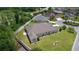 An aerial view showing the expansive backyard, mature greenery, and white vinyl fence at 2954 Heiny Pl, The Villages, FL 32163