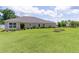 Spacious backyard featuring lush green grass, manicured landscaping, and room for outdoor activities at 2954 Heiny Pl, The Villages, FL 32163