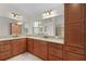 Bathroom featuring double sinks with granite counters and wooden cabinets at 2954 Heiny Pl, The Villages, FL 32163