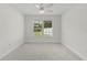 Cozy bedroom with neutral walls, carpeting, and a large window showcasing an outdoor view at 2954 Heiny Pl, The Villages, FL 32163