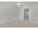 Neutral bedroom with neutral carpet and ceiling fan and view of hallway and closet at 2954 Heiny Pl, The Villages, FL 32163