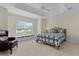 Bedroom featuring tray ceiling, an accent chair, window seat, and a large window at 2954 Heiny Pl, The Villages, FL 32163