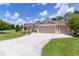 Charming home with a spacious driveway, a three-car garage, and beautiful landscaping at 2954 Heiny Pl, The Villages, FL 32163