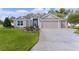 Charming single-story home with a well-manicured lawn, colorful flowerbeds, and a three car garage at 2954 Heiny Pl, The Villages, FL 32163