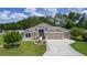 Charming single-story home featuring a well-manicured lawn, mature trees, and a neutral color scheme at 2954 Heiny Pl, The Villages, FL 32163