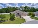 Beautifully landscaped home with a spacious driveway, green lawn and mature shade trees at 2954 Heiny Pl, The Villages, FL 32163