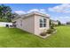 Exterior corner of a home with a well-kept lawn, screened-in porch, and mature landscaping at 2954 Heiny Pl, The Villages, FL 32163
