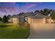 Twilight image of a well-kept single-story home with a three-car garage and manicured lawn at 2954 Heiny Pl, The Villages, FL 32163