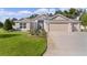 Charming one-story home with three-car garage, manicured lawn, and mature landscaping at 2954 Heiny Pl, The Villages, FL 32163